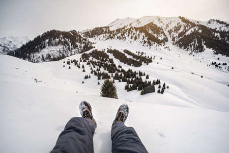 Hiker legs in tracking boots at amazing snowy mountains viewの写真素材