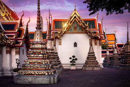 Ancient Royal Stupas and pagoda in Wat Pho temple in Bangkok at sunsetの写真素材