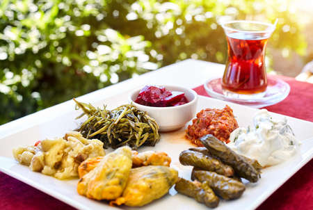 Turkish tea and meze vegetarian starter in restaurant in traditional glass on the red table in Turkeyの写真素材
