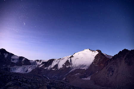 Snowy mountains under blue night sky full of stars in the Kazakhstanの写真素材