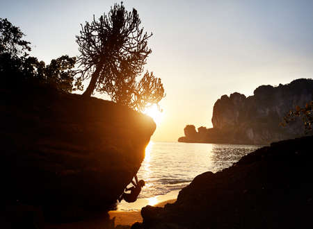 Rock climber in silhouette at Tonsai beach at sunset in Krabi, Thailandのeditorial素材