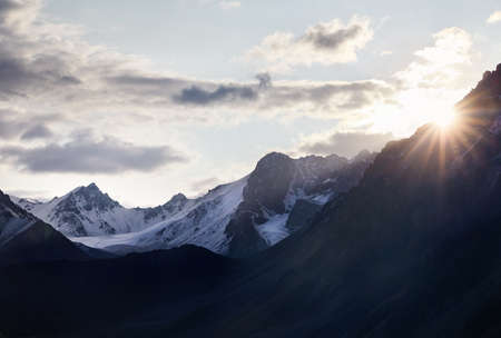 Beautiful landscape of snowy mountains with rising sun in Kazakhstan, Central Asia