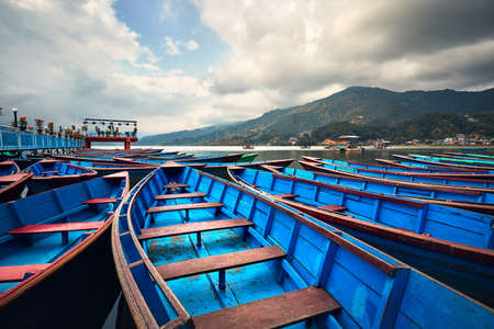 Blue boats at Phewa lake shore in Pokhara, Nepal.の写真素材