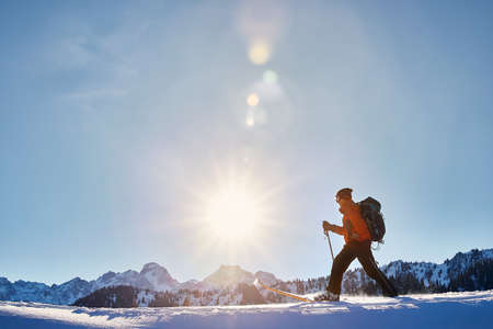 Man skiing on fresh powder snow at the mountains against sunny sky near Almaty, Kazakhstanの写真素材