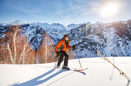 Man skiing on fresh powder snow at forest in the mountains near Almaty, Kazakhstanの写真素材