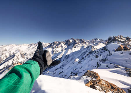 Man doing shaka gesture on the mountain peak with amazing view