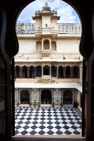 City Palace museum with checkered floor and beautiful architecture in Udaipur, Rajasthan, India. View from the arch window silhouette.のeditorial素材