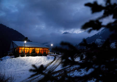 Modern wooden house decorated with yellow glowing bulbs at the mountain resortのeditorial素材