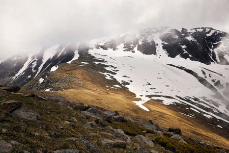 Landscape of snow mountain valley against cloudy sky in Kazakhstan
