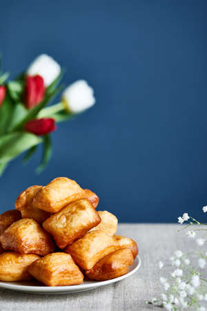 Kazakh national fry bread baursaks and tulips during Nauryz festival on blueの写真素材