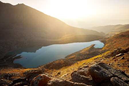 Beautiful scenery of big mountain lake at sunset light glow in Tien Shan Mountains, Kazakhstan.の写真素材