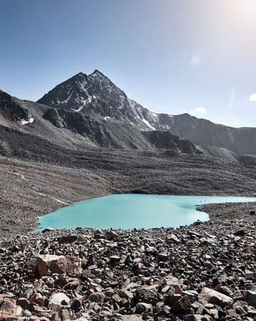 Beautiful scenery of rock at mountain lake with snow glacier in Tien Shan Mountains, Kazakhstan.の写真素材