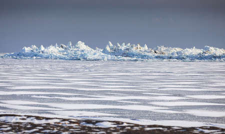 Beautiful landscape of big blue peace of Ice hummock castle and cracks at frozen lake with snow. Outdoor nature calendarの写真素材