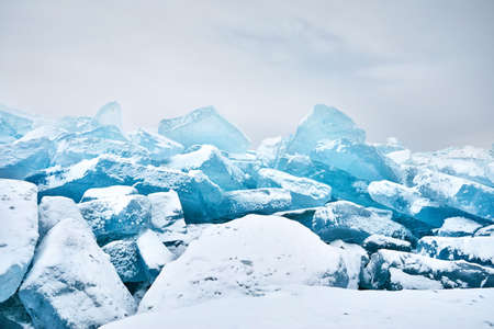 Beautiful landscape of big blue peace of Ice hummock and cracks at frozen lake with snow. Outdoor nature calendarの写真素材