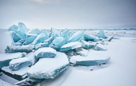 Beautiful landscape of big blue peace of Ice hummock and cracks at frozen lake with snow. Outdoor nature calendarの写真素材