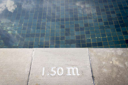 Pool depth sign at the edge of the swimming poolの写真素材