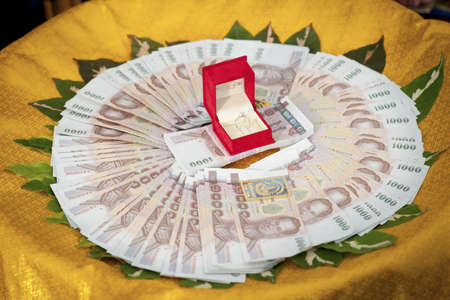 Wedding ring in a red box and Thai money for the brideの写真素材