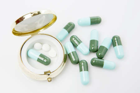 Pills and pill box on white background