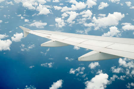 Wing of an airplane flying above the cloudsの写真素材
