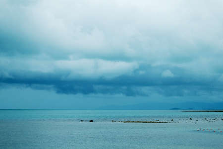 Cloudy blue sky  above a blue surface of the seaの写真素材
