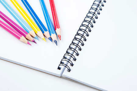 notebook with color pencils on background