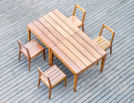Wooden dining tables in lush garden