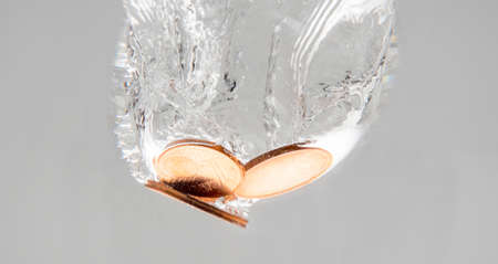 Euro coins falling into the clear waterの写真素材