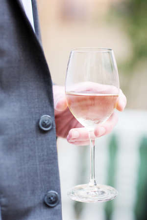 Person holding a half full glass of wineの写真素材