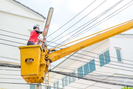 Electrician lineman repairman worker at climbing work on electricのeditorial素材