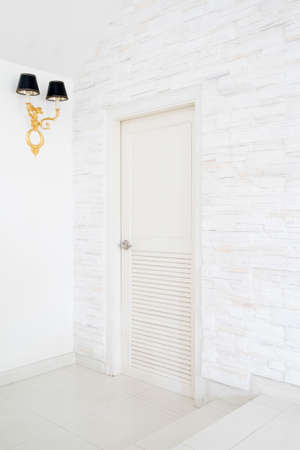 Closed White Door and vintage golden lamp on texture Wallの写真素材