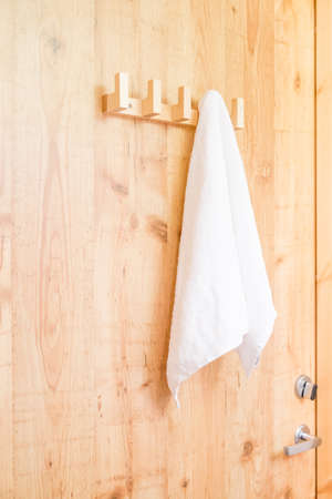 Hanging White Towel draped on Exposed Concrete Wall in the Bathroomの写真素材