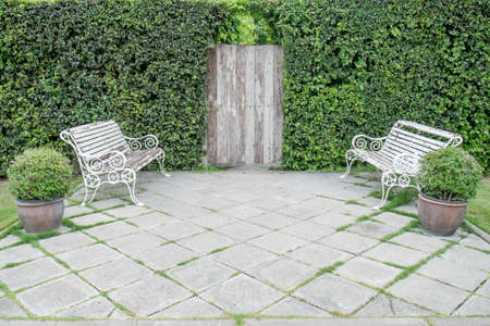 white benches in a green garden