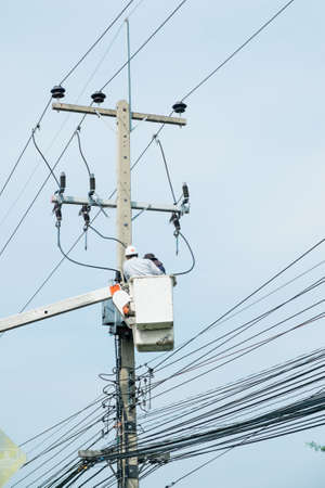 Electrician lineman repairman worker at climbing work on electri