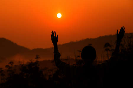 Silhouette of the women raise handの写真素材