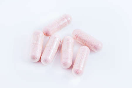 Capsules of green herbal supplement product isolated on white backgroundの写真素材