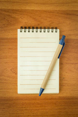 blank spiral notepad and pencil on wood backgroundの写真素材