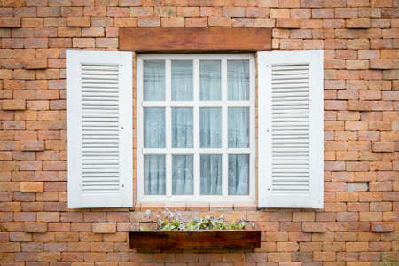Wooden window and flower on brick backgroundの写真素材