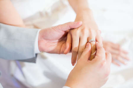 Close up Groom Put the Wedding Ring on brideの写真素材