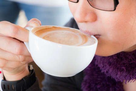 Close up of womenâs mouth drinking coffeeの写真素材