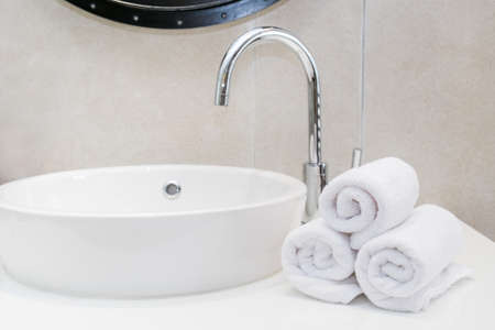 Stacked white spa towels in modern bathroomの写真素材