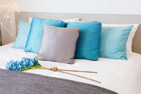 stylish bedroom interior design with colorful pillows on bed and decorative table lamp.の写真素材