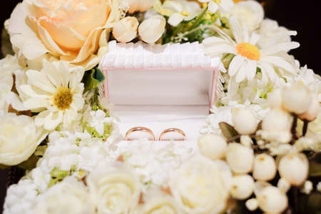 wedding rings on the box with flower