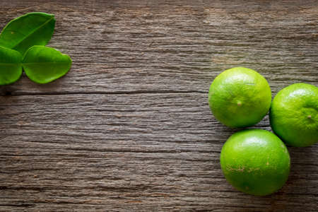 lemon with green leafs on wood backgroundの写真素材