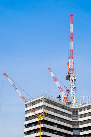 three lifting crane and building under construction
