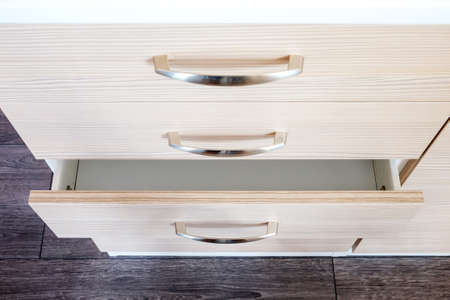 a wooden wardrobe drawer front, metal handle