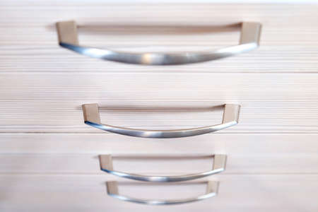 a wooden wardrobe drawer front, metal handle