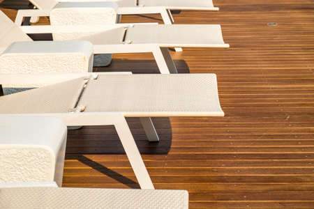 chair around outdoor swimming pool in hotelの写真素材