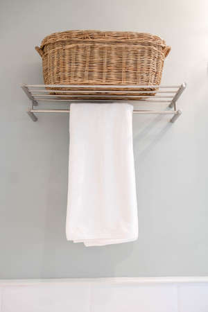 Clean white towel on a hanger prepared to use in bathroomの写真素材