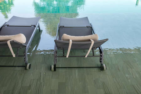 chair around outdoor swimming pool in hotelの写真素材