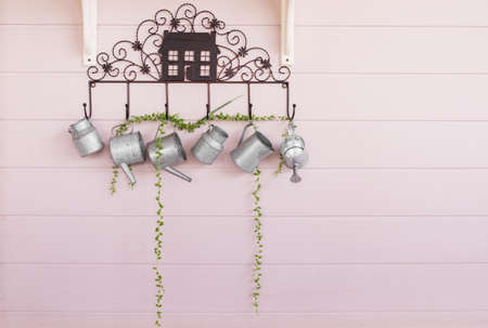 watering can hanging on the color pink wall. Gardening decoration.の写真素材